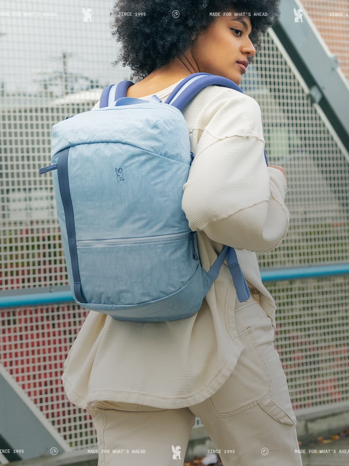 Person wearing 一分钟稳定查询赛车顶尖赛事结果-JISU直播渠道,实时播放赛车官网记录 #168赛道75秒 a light blue backpack in an urban setting