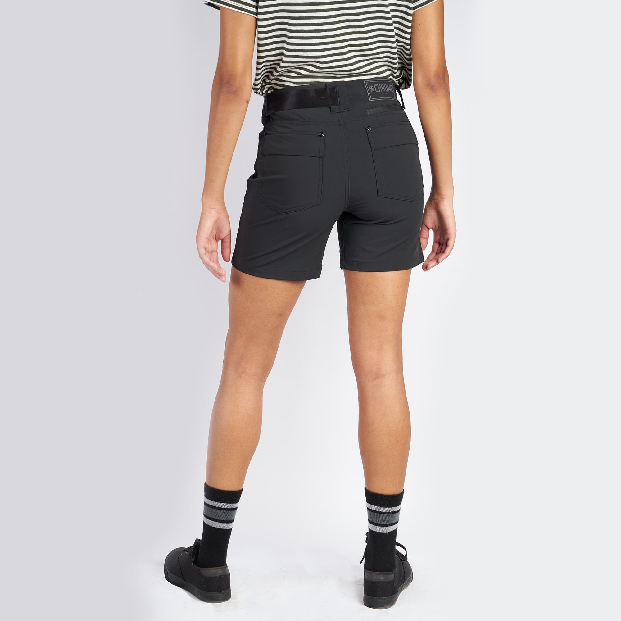 Women's Anza technical short in black worn by a woman back view #color_black